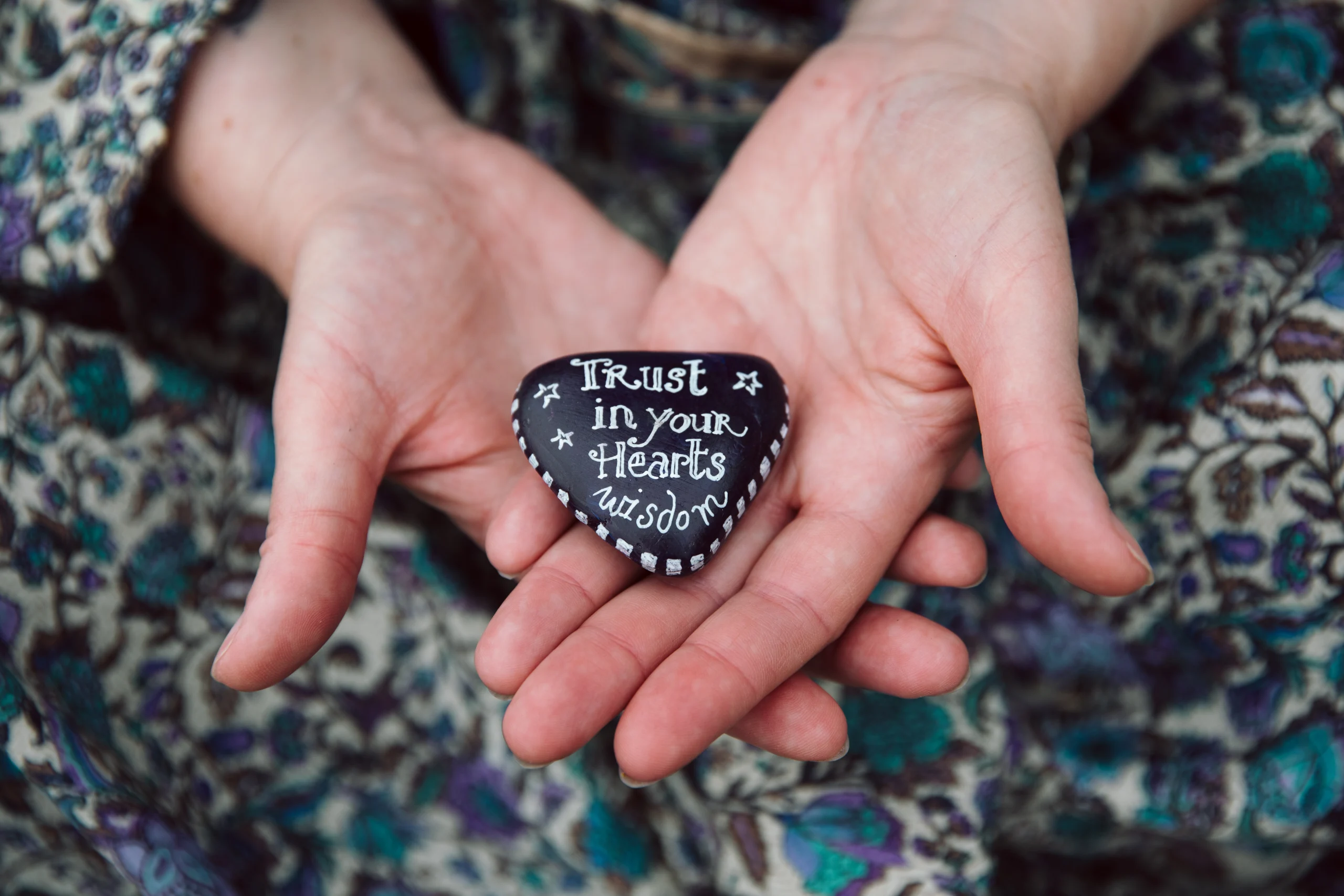 Sophie Messager holding a penchant with the quote "Trust in your hearts wisdom"